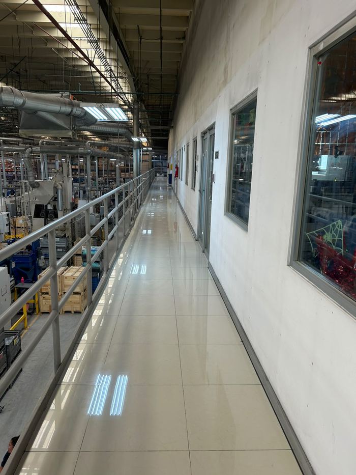 Pasillo de mezzanine en nave industrial con piso reluciente