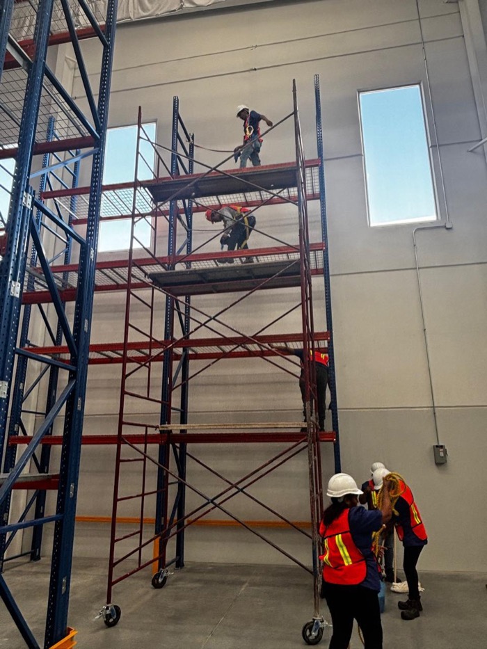 Equipo de Satera con equipo de seguridad supervisando trabajo en altura sobre andamio
