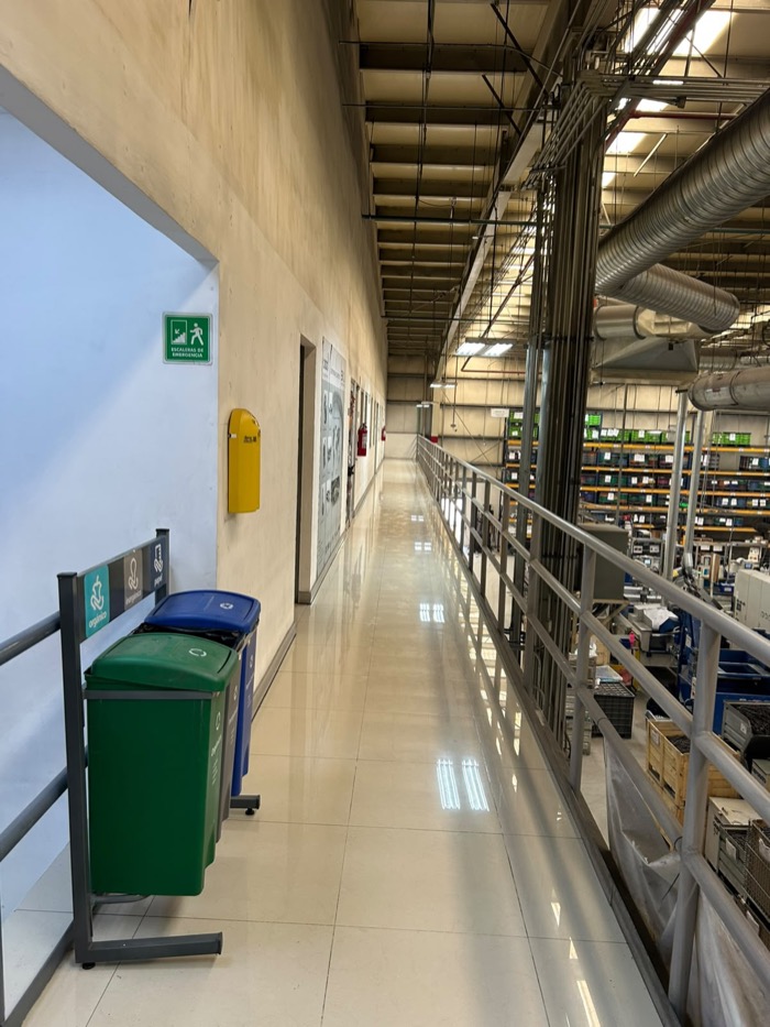 Pasillo elevado tipo mezzanine con piso reluciente en instalación industrial